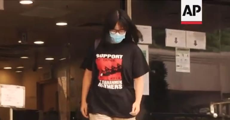 Hong Kong lawyer Chow Hang-tung walks down steps wearing a t-shirt that says "Support the Tiananmen mothers"