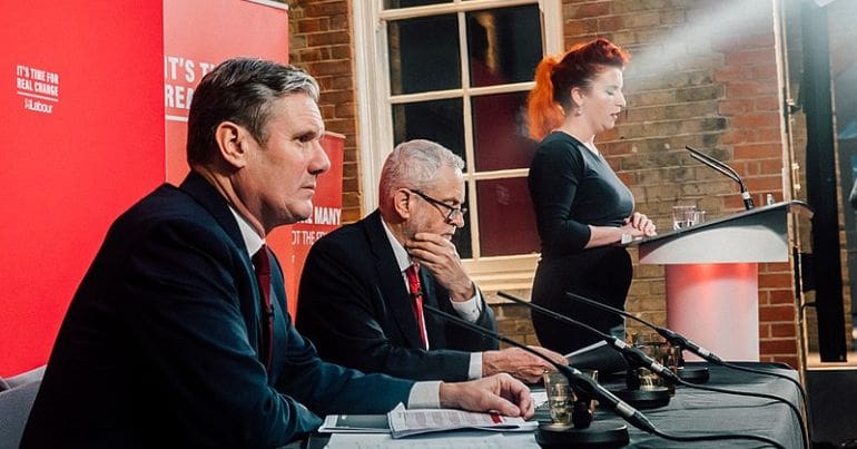 Starmer listens to a Corbyn speech