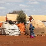 A woman walking past tents in Somalia