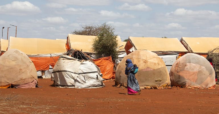 A woman walking past tents in Somalia