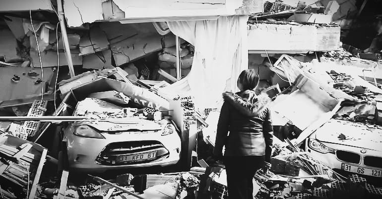 A woman looking at the earthquake devastation in Hatay, Turkey - a Kurdish area