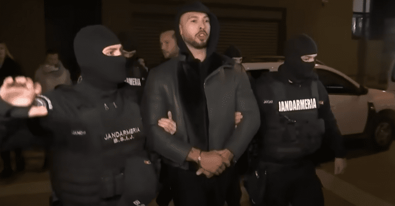 Andrew Tate is led away by police officers