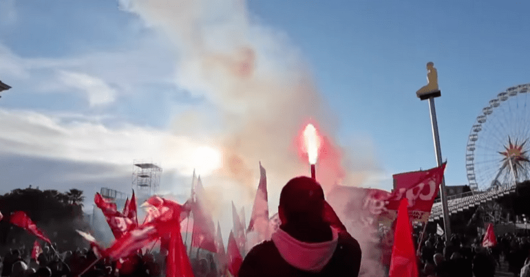 Protestor lights a flare in France, pension strikes ramped up by trade unions