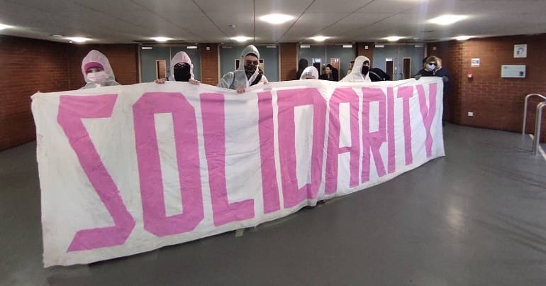 Students with a banner that says solidarity - they've been occupying universities in support of the UCU strike
