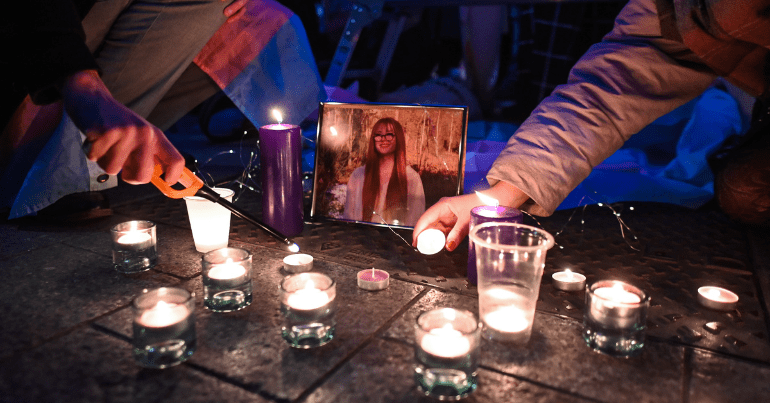 candles are lit at a vigil in front of a photo of Brianna Ghey