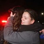 Two people hug in grief following gun violence and a mass shooting at Michigan State University