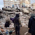People look at rubble of collapsed building following the earthquake in Turkey