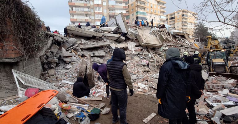 People look at rubble of collapsed building following the earthquake in Turkey