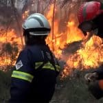 Firefighters look on as wildfires burn in Spain, which the PM says is a sign of the climate emergency