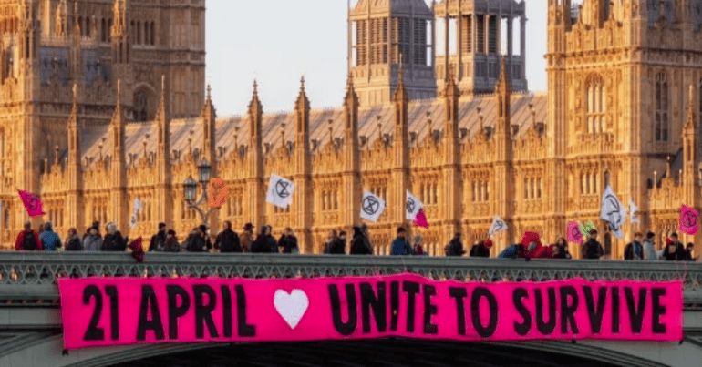 An Extinction Rebellion banner outside the houses of parliament which reads '21 April - Unite to Survive' relating to The Big One