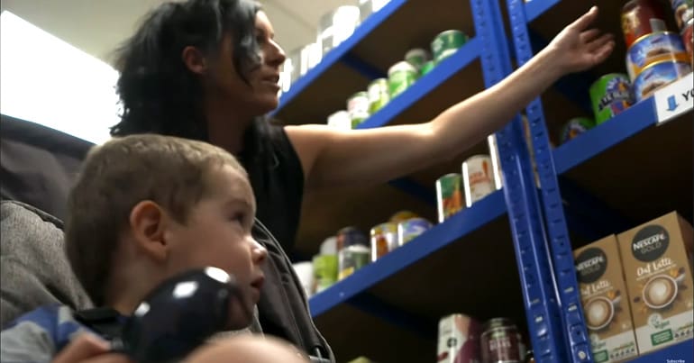 Mother and son at a food bank putting together a food parcel
