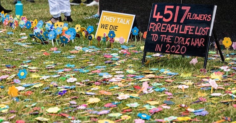 Fake flowers laid over the war on drugs by Anyone's Child as part of Support. Don't Punish
