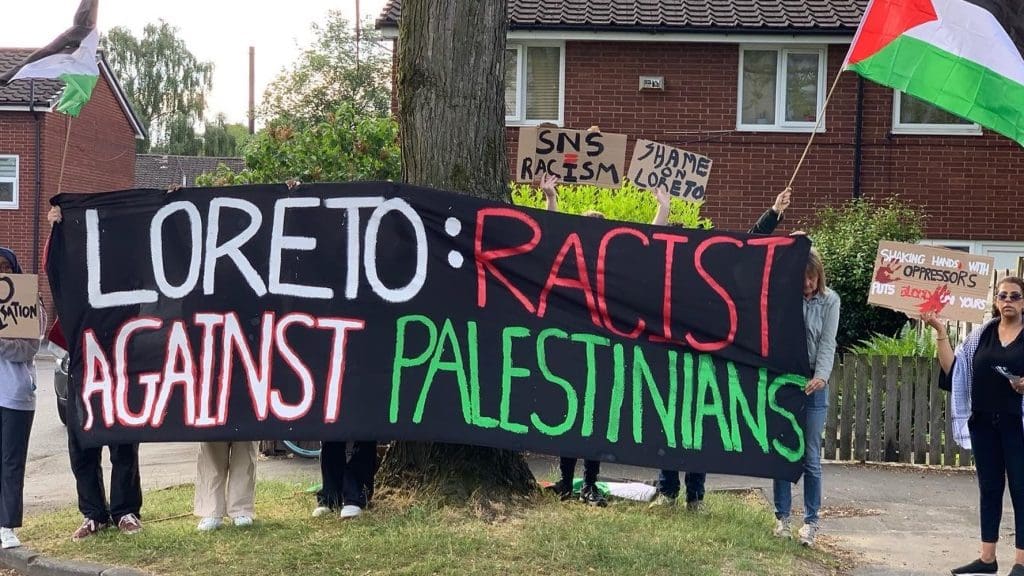 Youth Front for Palestine hold a banner during a demonstration against Loreto High School's hosting of Solutions Not Sides