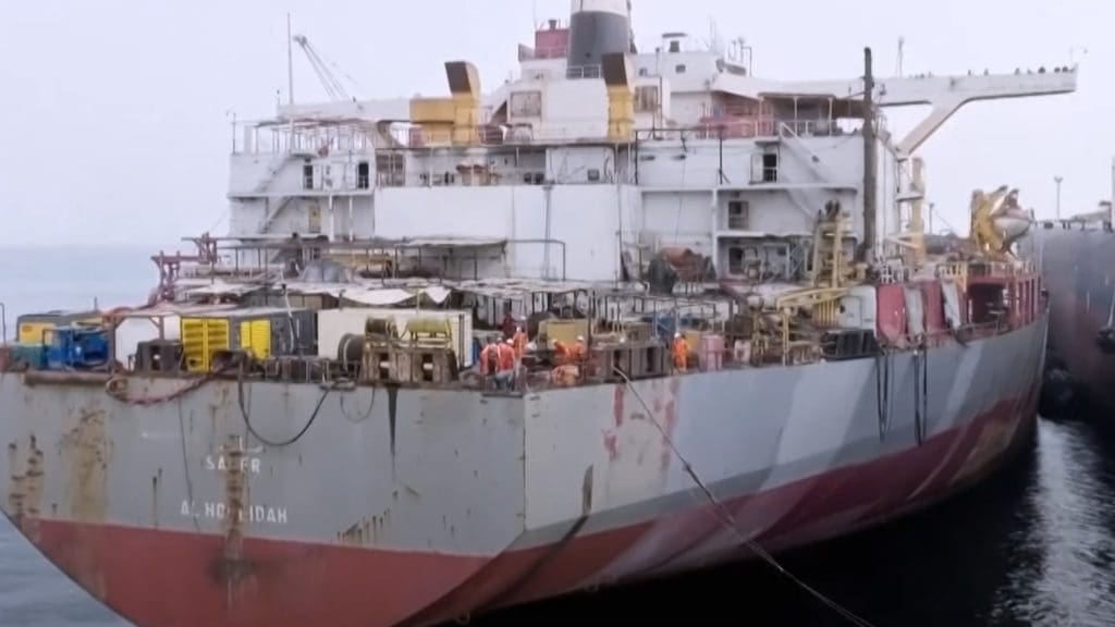 Workers on the SAFER oil tanker near Yemen transfer oil to nearby vessel.