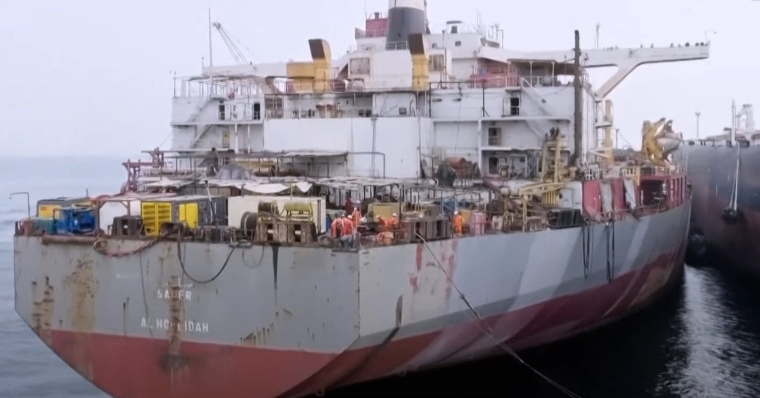 Workers on the SAFER oil tanker near Yemen transfer oil to nearby vessel.