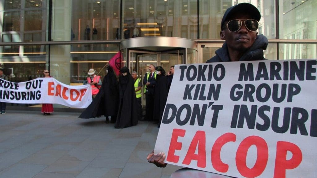 Protesters demonstrate with placards against the EACOP project, outside insurance company offices. Banner reads: Rule out insuring EACOP. Placard reads: Tokio Marine Kiln Group don't insure EACOP.