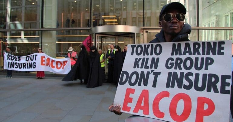 Protesters demonstrate with placards against the EACOP project, outside insurance company offices. Banner reads: Rule out insuring EACOP. Placard reads: Tokio Marine Kiln Group don't insure EACOP.