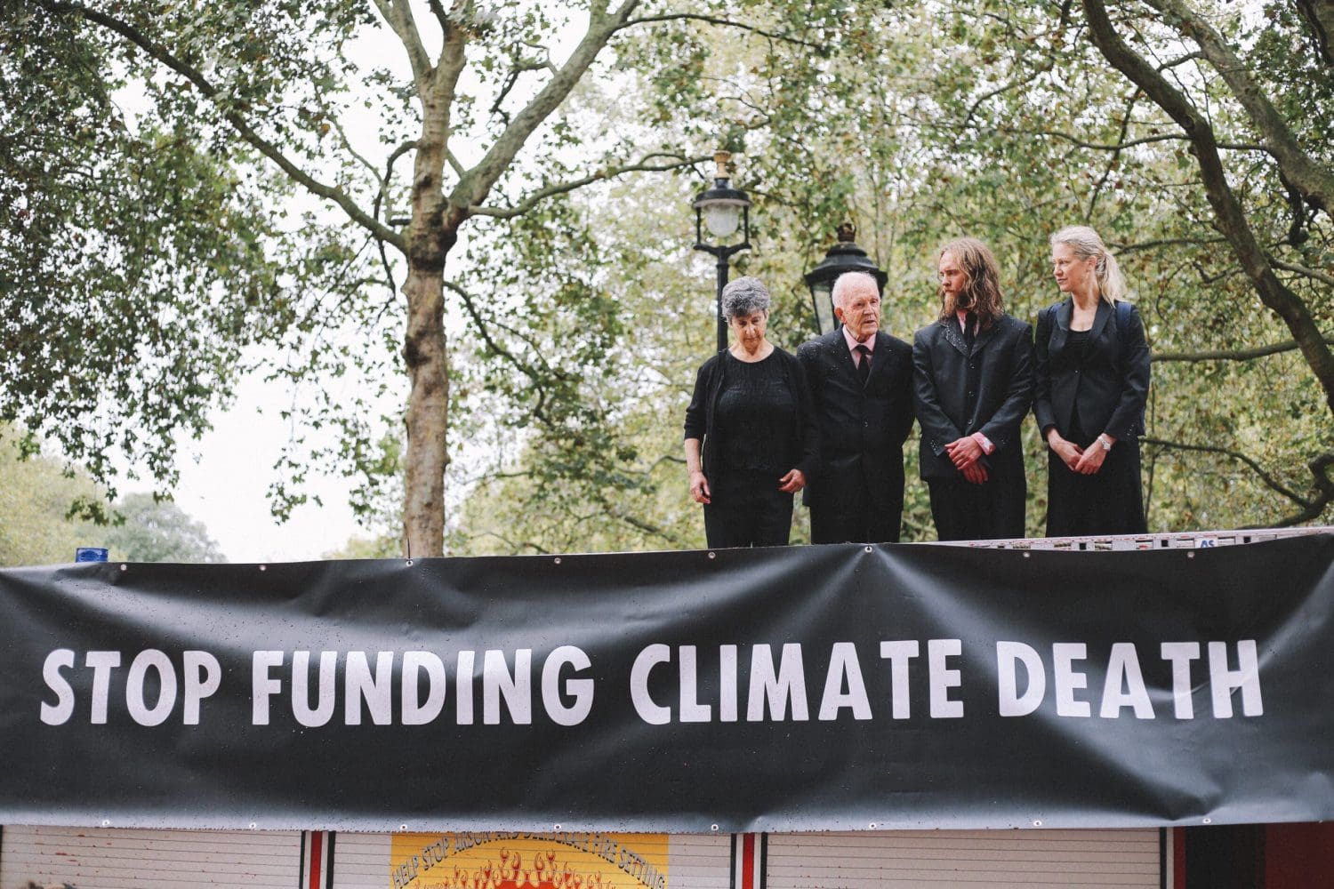 Banner reading "STOP FUNDING CLIMATE DEATH"