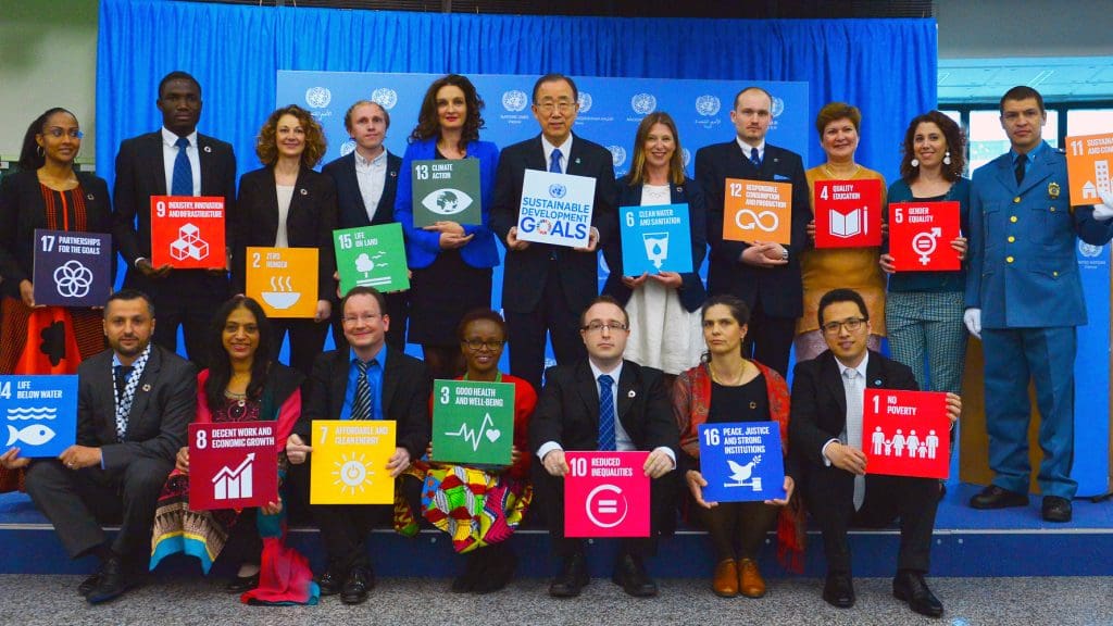 Members of volunteer staff and former secretary general Ban Ki-moon hold up Sustainable Development Goal placards at a summit in 2016.