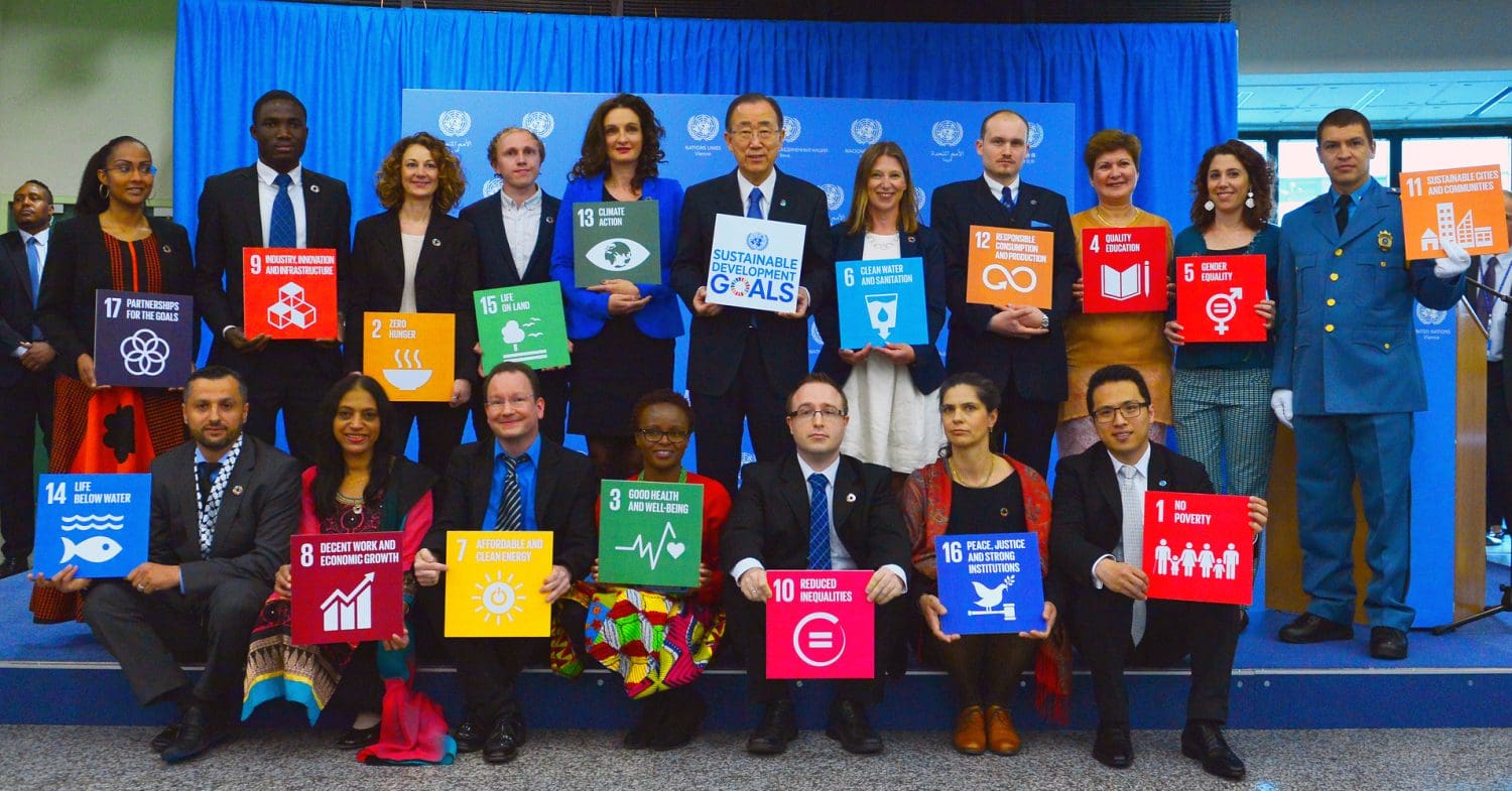 Members of volunteer staff and former secretary general Ban Ki-moon hold up Sustainable Development Goal placards at a summit in 2016.