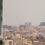 Greater Nile Petroleum Operating Company Tower on fire next to picture of Khartoum's skyline with smoke pouring from a building amid Sudan's civil war