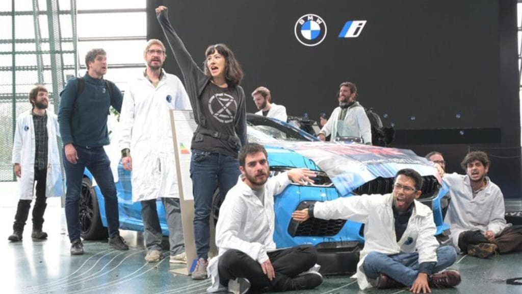Scientists Rebellion activists glue their hands to a BMW vehicle in protest over the companies lobbying against climate action.