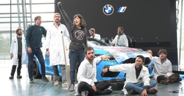 Scientists Rebellion activists glue their hands to a BMW vehicle in protest over the companies lobbying against climate action.