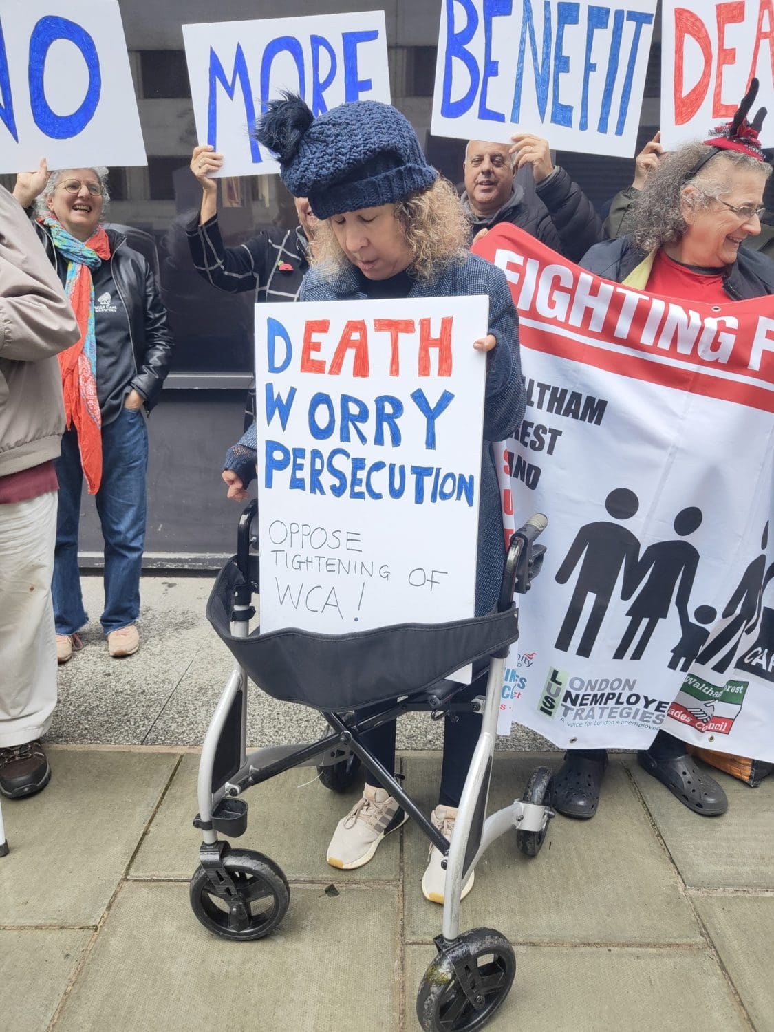 a placard that reads 'death, worry, persecution, oppose tightening of the WCA' to represent the DWP