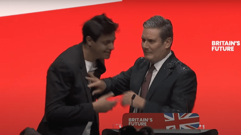 Electoral reform protester showers Keir Starmer in glitter at the start of his keynote conference speech.