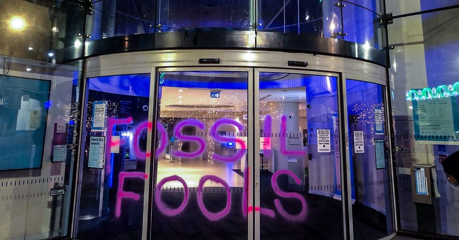 Barclays branch with 'fossil fuels' painted on it Extinction Rebellion