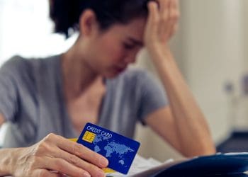 A woman holding a credit card TUC debt