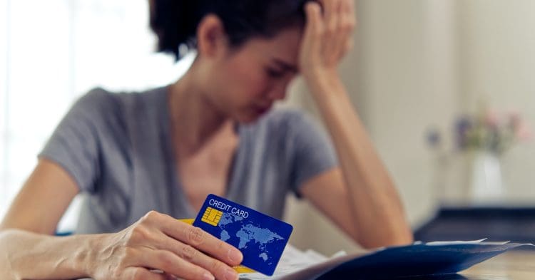 A woman holding a credit card TUC debt