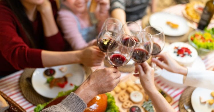 Family toasting with wine around a Christmas table