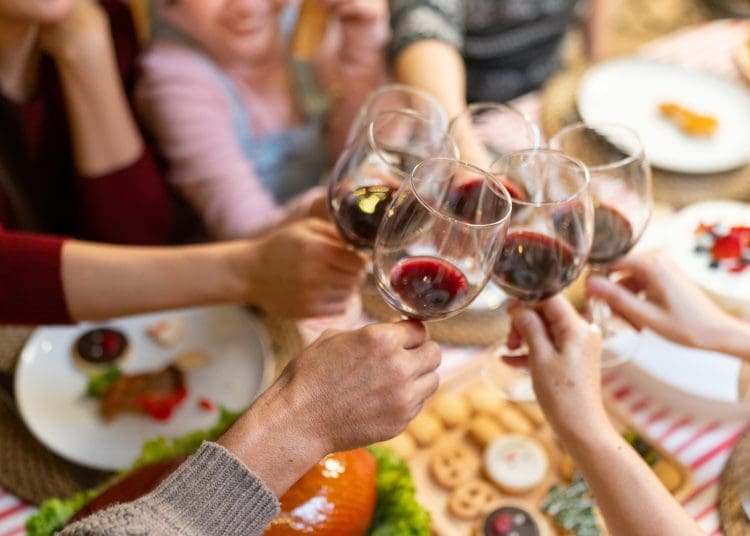 Family toasting with wine around a Christmas table