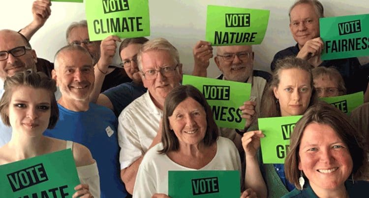 Green Party members holding signs
