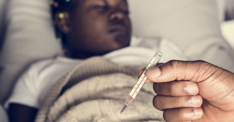 cost of living crisis a girl with someone holding a thermometer