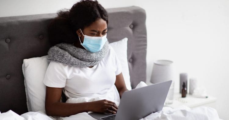 A woman wearing a mask in bed sick pay TUC
