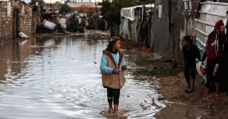 Gaza climate crisis a girl standing in flood water
