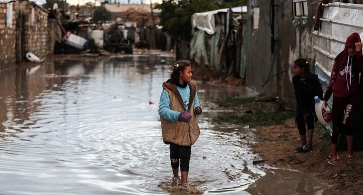 Gaza climate crisis a girl standing in flood water
