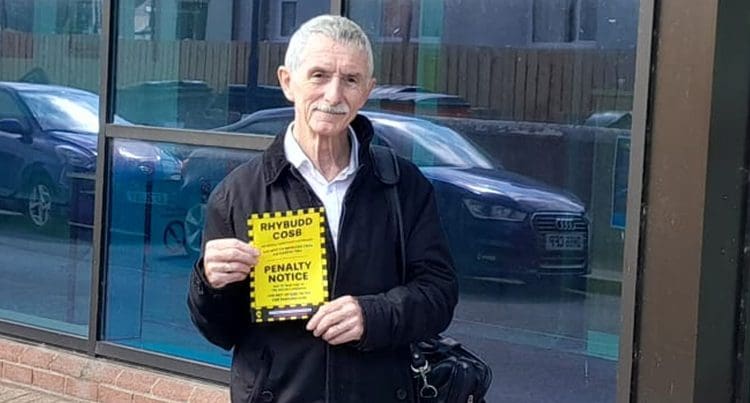 Welsh language campaigner holding a parking fine