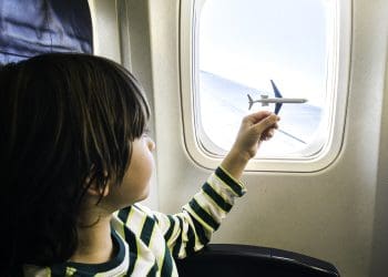 boy playing with model plane on a plane aerotoxic syndrome