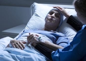 A severely ill person with someone touching their head ME NHS