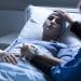A severely ill person with someone touching their head ME NHS