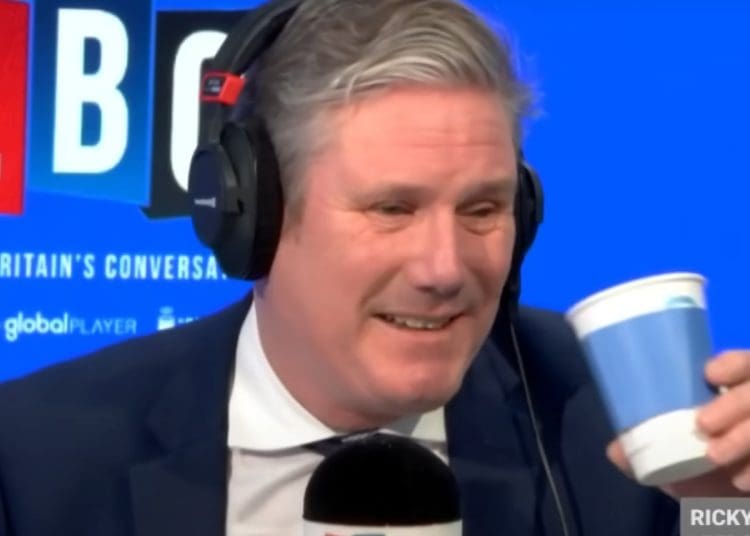 Starmer drinking a drink and smirking