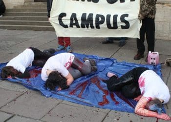 Bristol University arms off campus protests students doused in fake blood lying down