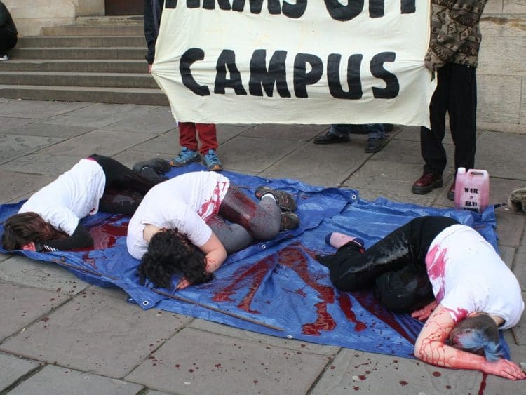 Bristol University arms off campus protests students doused in fake blood lying down