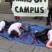 Bristol University arms off campus protests students doused in fake blood lying down