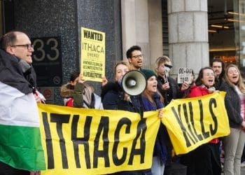 Fossil Free London activists protest outside Ithaca Energy's London office with Palestinian flags and a banner that reads: "Ithaca Kills".