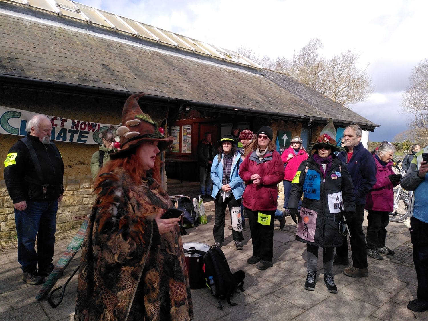 Environmental activists gather before setting off on a 3km march to Wytch Farm oil field. A protester leads the group in song. 