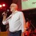 Jeremy Corbyn holding a mic in front of a band